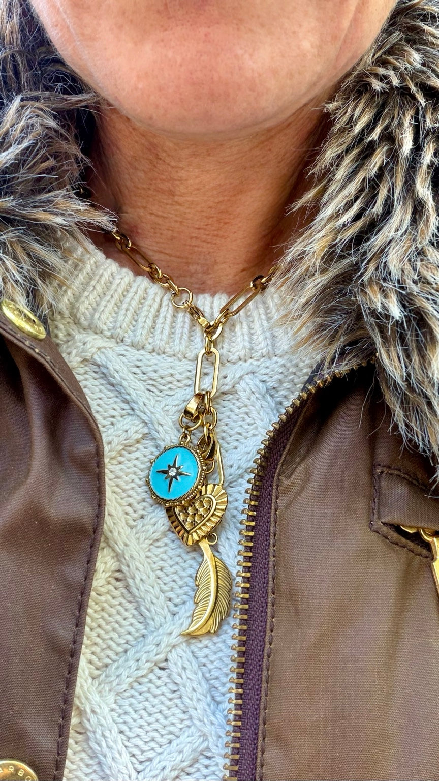 Free Spirit gold charm necklace worn with a cream knit sweater